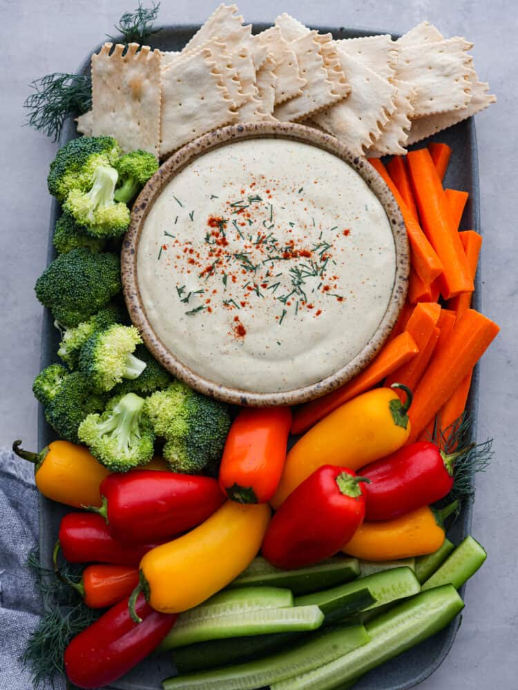 Don't underestimate cottage cheese, because once you taste this flavorful dip loaded with herbs, spices, and hard-boiled eggs (reminiscent of deviled eggs), you'll keep coming back for seconds and thirds. Cottage cheese dip on a serving board with vegetables and crackers.